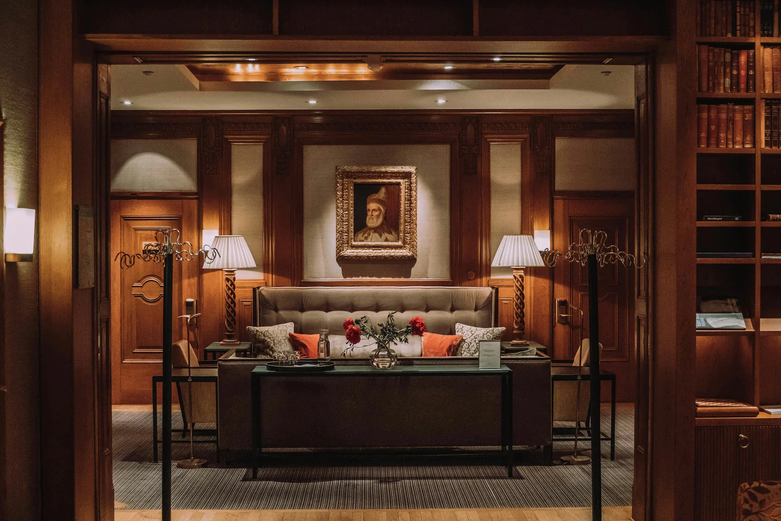 Lounge clássico de hotel com poltronas estofadas e obras de arte
