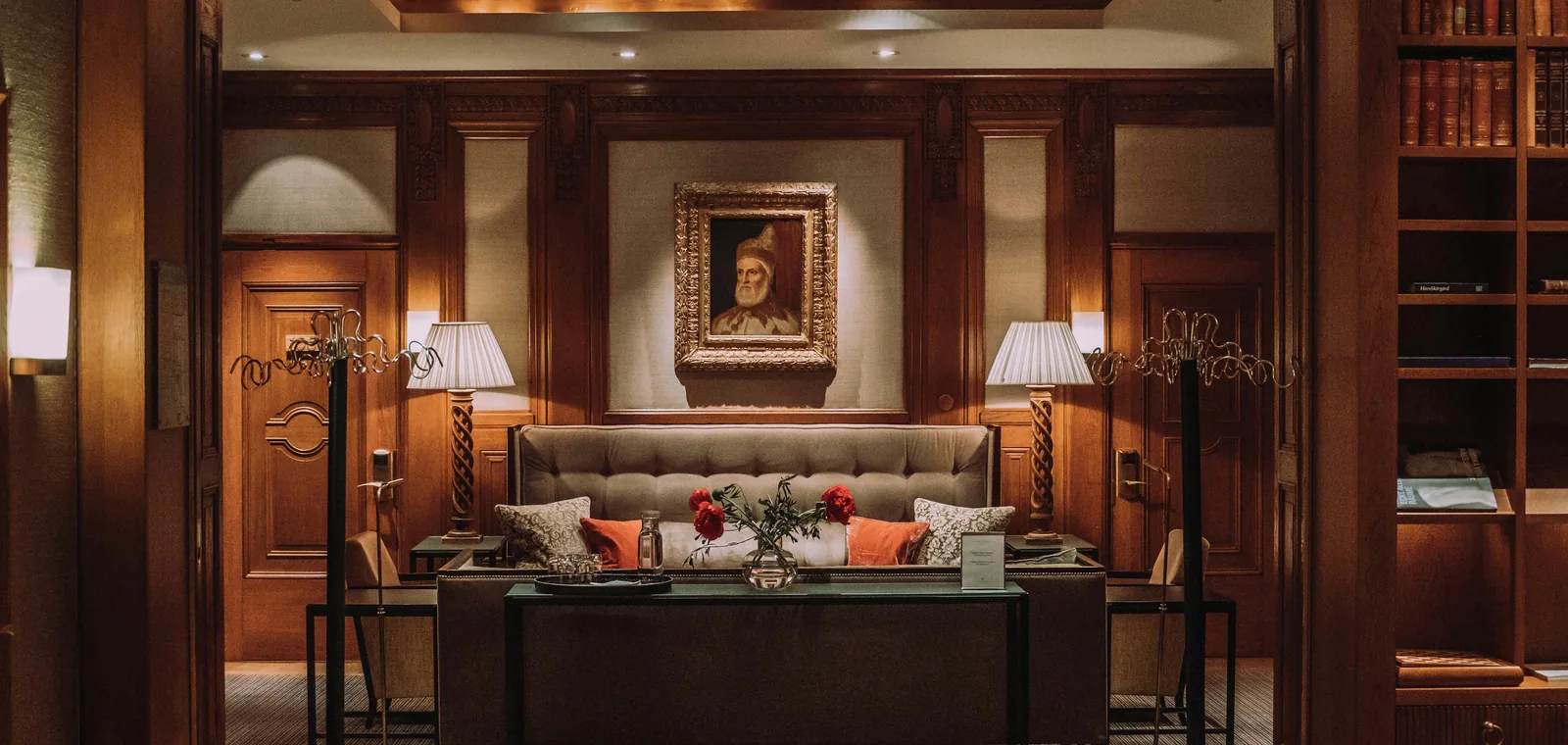 Lounge executivo de hotel com estante de livros e retrato emoldurado