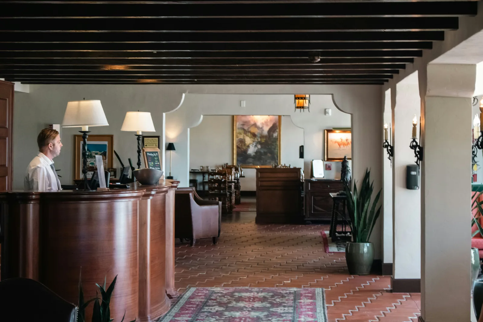 Recepcionista atendendo na recepção de um hotel de estilo clássico